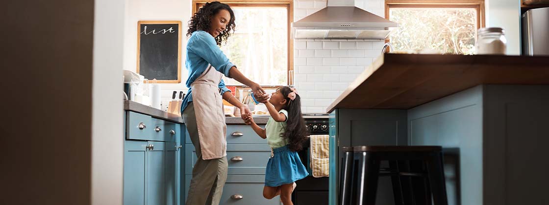 Una mamá y su hija haciendo juegos lúdicos en la cocina