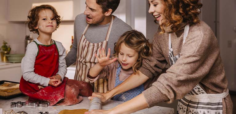 Una familia teniendo buena comunicación familiar mientras cocinan la cena