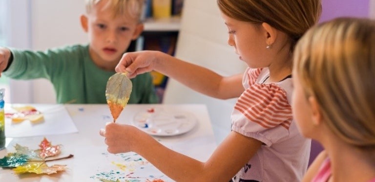 Unos hermanos haciendo actividades de arte para niños en una mesa