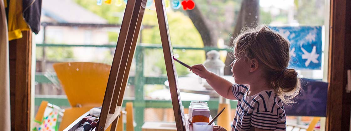 Una niña haciendo actividades de arte en un lienzo