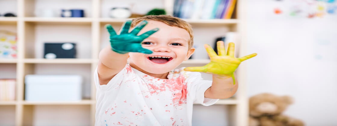 Un niño haciendo actividades de arte pintando con sus manos