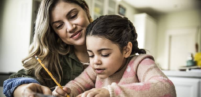 Una mamá y su hija haciendo ejercicios de escritura para niños