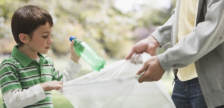 Un niño haciendo actividades de responsabilidades reciclando