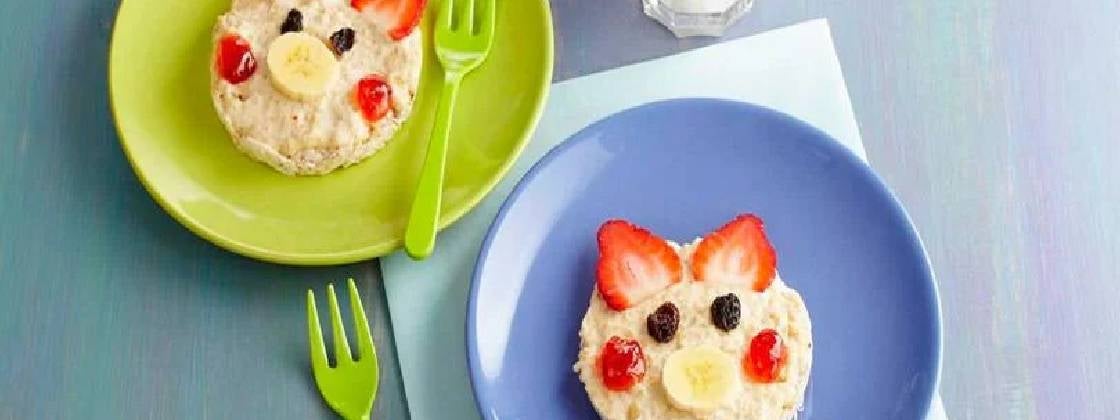 Unos cerditos sobre galletas de arroz siendo un desayuno creativo para niños