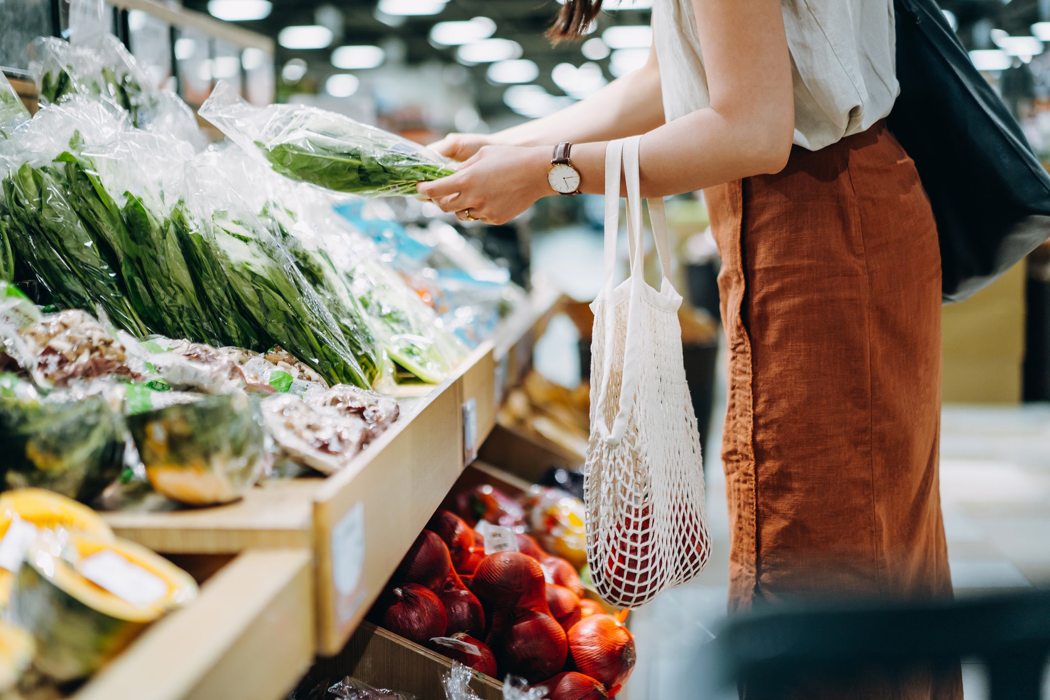 Una mujer comprando variedad de vegetales para crear una comida balanceada