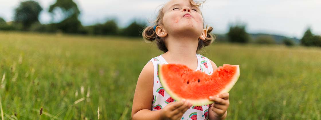 Una niña desarrollando la memoria sensorial con una sandia