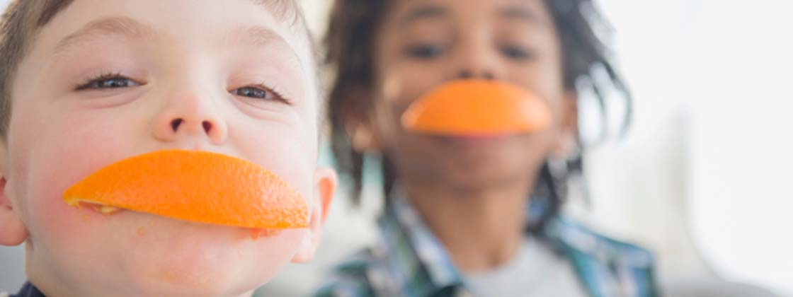 Dos niños jugando con las naranjas luchadoras desarrollando su memoria sensorial